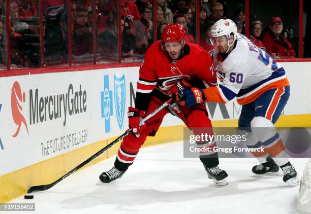 Adam Pelech of the New York Islanders checks puck carrier Lee Stempniak of the Carolina Hurricanes during an NHL game on February 16, 2018 at PNC...