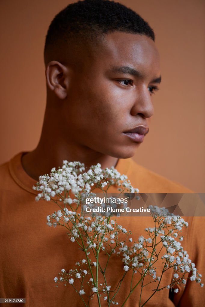 Profile of young man holding flowers