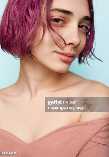 young woman with colorful hair flying over her face - purple hair stockfoto's en -beelden