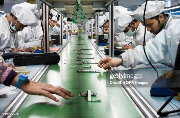 Workers assemble smartphones on the production line inside the Intex Technologies brand plant in Noida. Intex Technologies is a Smartphone...