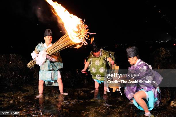 Shrine priests crop seaweeds under flaming torch during the Mekari Ritual at Mekari Shrine on February 16, 2018 in Kitakyushu, Fukuoka, Japan. The...