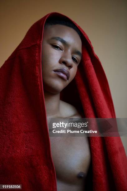 Young man looking directly to camera with towel draped over head