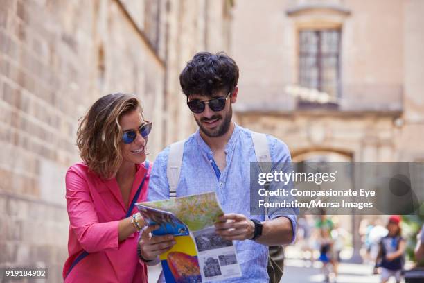 smiling couple with map on street in barcelona - tourist map stock pictures, royalty-free photos & images