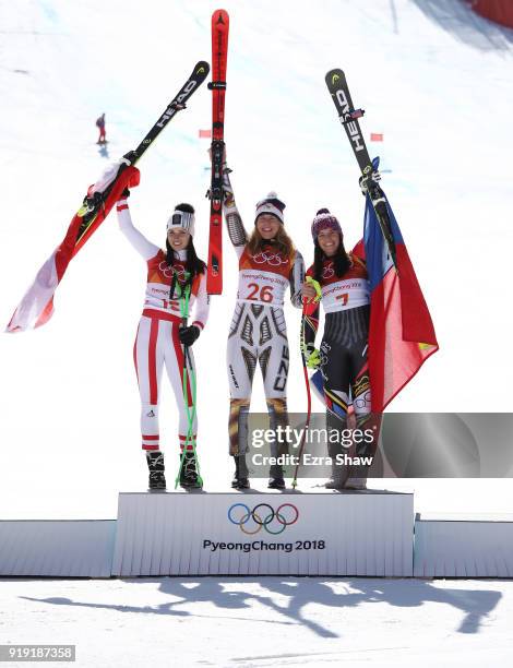 Gold medallist Ester Ledecka of the Czech Republic celebrates with silver medallist Anna Veith of Austria and bronze medallist Tina Weirather of...