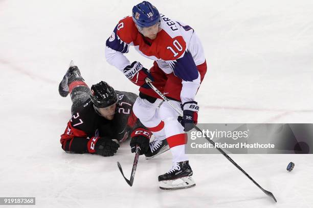 Cody Goloubef of Canada fights for the puck with Roman Cervenka of the Czech Republic during the Men's Ice Hockey Preliminary Round Group A game on...