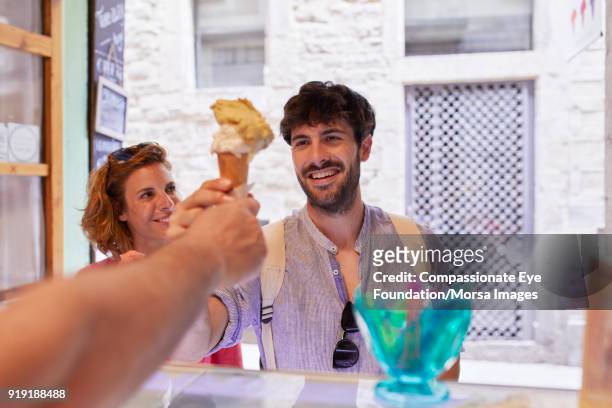 smiling couple buying ice cream cone in shop - man eye cream stock pictures, royalty-free photos & images