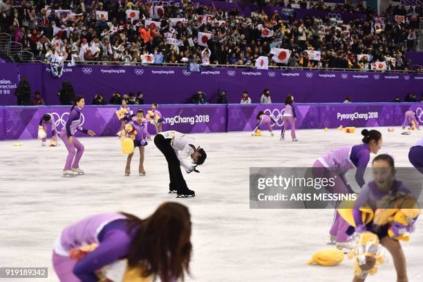 Volunteers collect Winnie the Pooh teddy bears thrown by supporters of Japan's Yuzuru Hanyu after the men's single skating free skating of the figure...