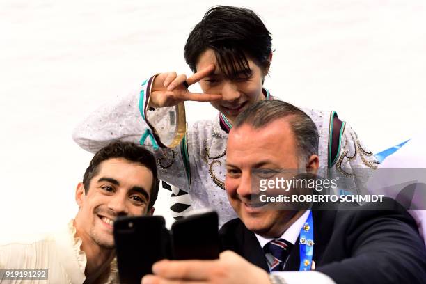 Winner Japan's Yuzuru Hanyu poses for a photo with Japan coach Ghislain Briand and third-placed Spain's Javier Fernandez during the venue ceremony...