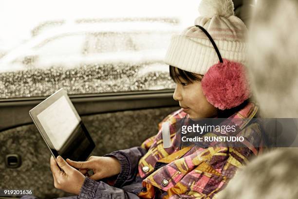 girl using digital tablet in car - girl in car with ipad ストックフォトと画像