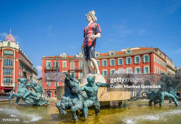 the apollo statue in the fontaine du soleil on place masséna, nice, côte d'azur, wears the colours of the ogc nice soccer team - ogc nice soccer team imagens e fotografias de stock