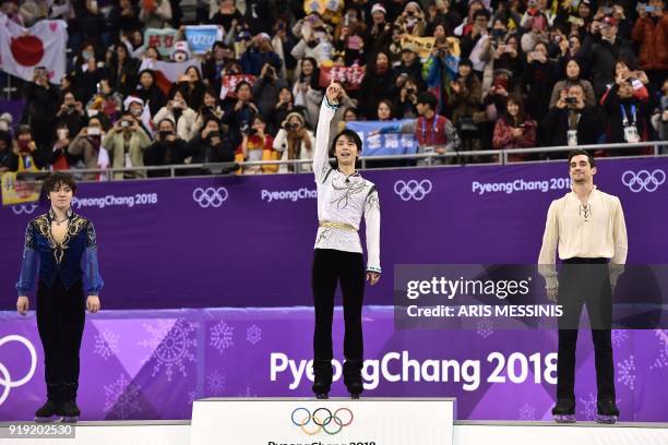 Silver medallist Japan's Shoma Uno, gold medallist Japan's Yuzuru Hanyu and bronze medallist Spain's Javier Fernandez celebrate on the podium during...