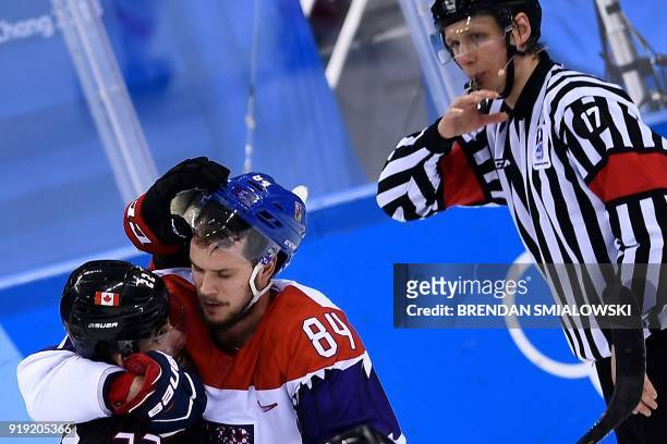 Canada's Eric O'Dell and Czech Republic's Tomas Kundratek fight during overtime of the men's preliminary round ice hockey match between Canada and...