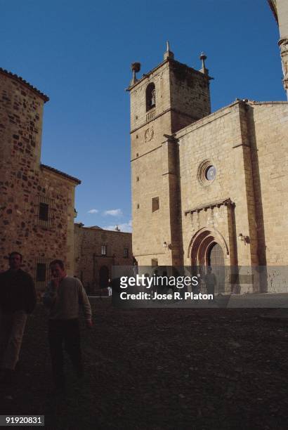 Cathedral of Santa María. Old Town. Caceres Several people go for a walk next to the church or cathedral of Gothic style, in the monumental center of...