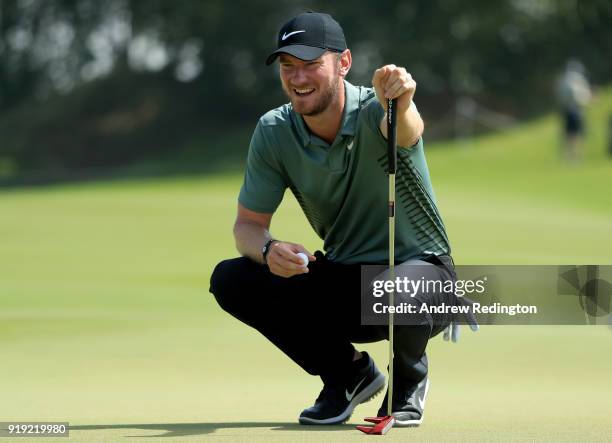 Chris Wood of England lines up his putt on the first green during the third round of the NBO Oman Open at Al Mouj Golf on February 17, 2018 in...