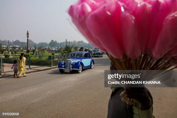 An Indian family drives around India Gate in a vintage car during the '21 Gun Salute International Vintage Car Rally and Concours Show' in New Delhi...
