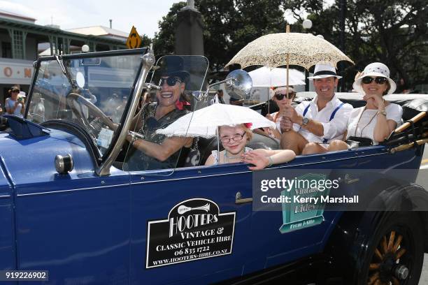 People dressed in period costumes take rides in vintage cars during the Art Deco Festival on February 17, 2018 in Napier, New Zealand. The annual...