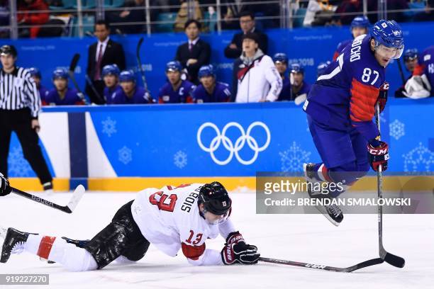 South Korea's Minho Cho trips over Switzerland's Felicien Du Bois during the second period of a men's preliminary round ice hockey match between...