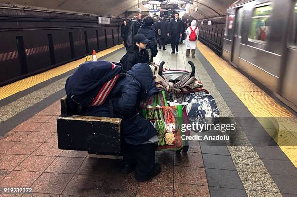 Homeless person with belongings sleeps on a bench during freezing temperatures at the 5th Avenue in New York, United States on February 16, 2018. On...