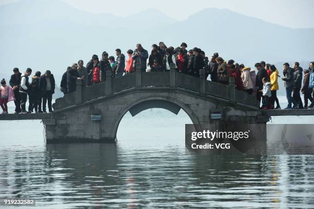 Tourists flock to a bridge on West Lake on the second day of Spring Festival on February 17, 2018 in Hangzhou, Zhejiang Province of China.The 2018...