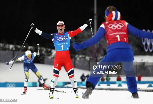 Marit Bjoergen of Norway celebrates as she crosses the finish line to win gold with Ingvild Flugstad Oestberg of Norway during the Ladies' 4x5km...