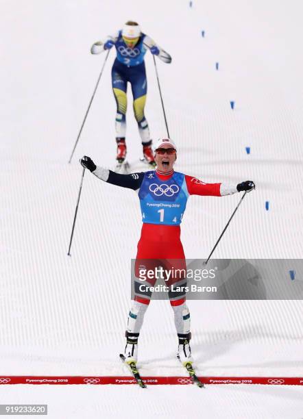 Marit Bjoergen of Norway celebrates as she crosses the finish line to win gold ahead of Stina Nilsson of Sweden during the Ladies' 4x5km Relay on day...