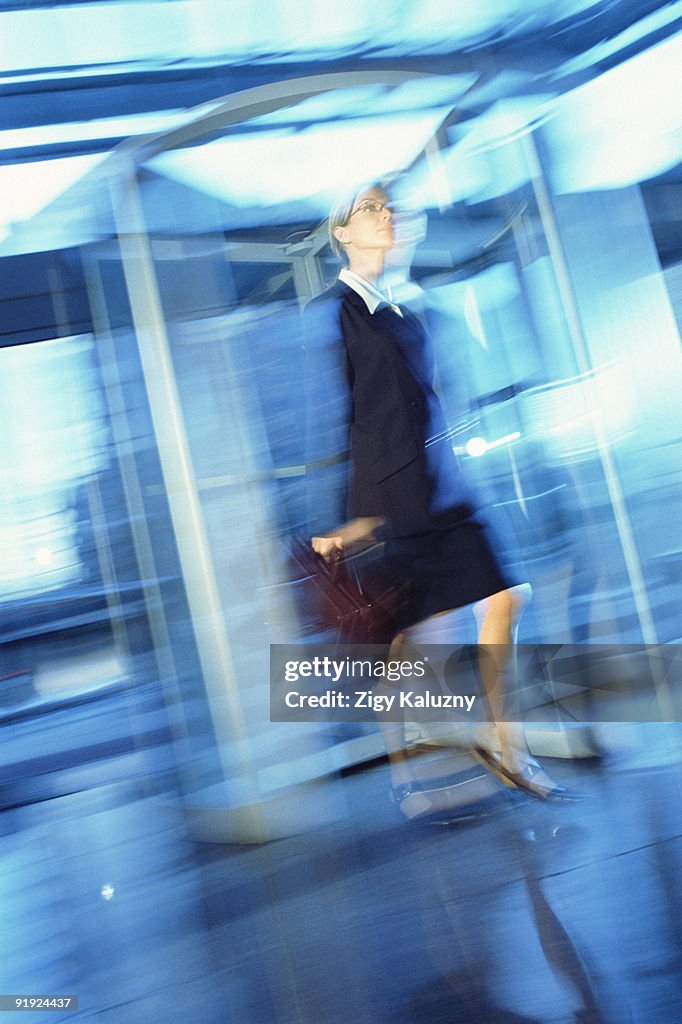 Businesswoman walking through a revolving door