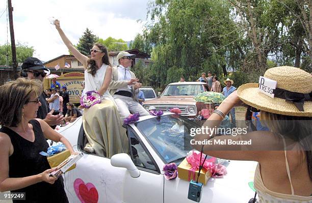 Julia Roberts and Daniel Moder impersonators wave to onlookers during the Fourth of July parade on July 4, 2002 in Arroyo Seco, New Mexico. Roberts...