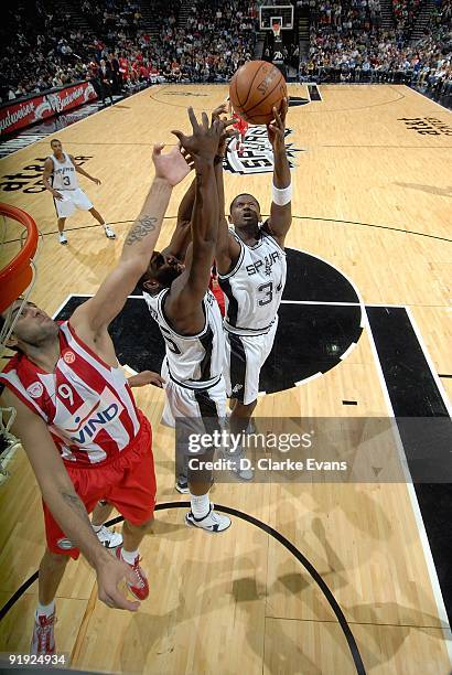 DeJuan Blair and Antonio McDyess of the San Antonio Spurs go up for the rebound against Ioannis Bourousis of the Greece Olympiacos during the...