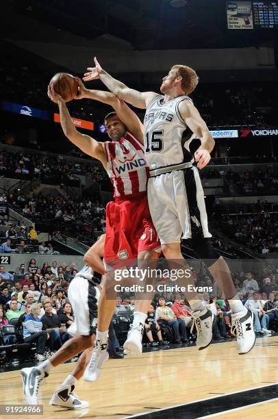 Linas Kleiza of the Greece Olympiacos rebounds the ball against Matt Bonner of the San Antonio Spurs during the exhibition game on October 9, 2009 at...