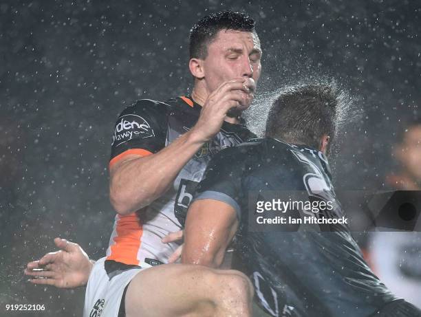 Tyson Gamble of the Tigers is hit by Sam Hoare of the Cowboys during the NRL trial match between the North Queensland Cowboys and the Wests Tigers at...