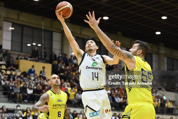 Ryuichi Kishimoto of the Ryukyu Golden Kings shoots while under pressure from Josh Harrellson of the Sunrockers Shibuya during the B.League match...