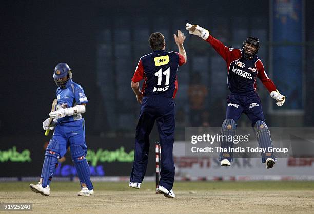 Glenn McGrath celebrates a wicket with Dinesh Karthik during the Delhi Daredevils vs Wayamba match at the Kotla Stadium.