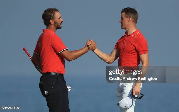 Joost Luiten and Daan Huizing shake hands on the 18th hole during the third round of the NBO Oman Open at Al Mouj Golf on February 17, 2018 in...