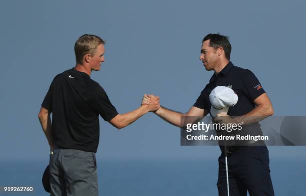 Marcus Kinhult of Sweden and Julien Guerrier of France shake hands on the 18th hlole during the third round of the NBO Oman Open at Al Mouj Golf on...