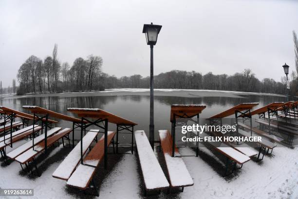 Snow covers benches and tables of a park cafe at the Englischer Garten park in Munich, southern Germany, on February 17, 2018. / AFP PHOTO / dpa /...