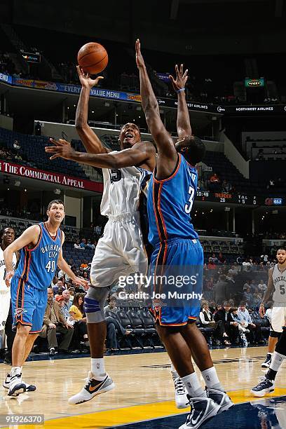 Steven Hunter of the Memphis Grizzlies hooks a shot over D.J. White of the Oklahoma City Thunder during the preseason game on October 7, 2009 at...