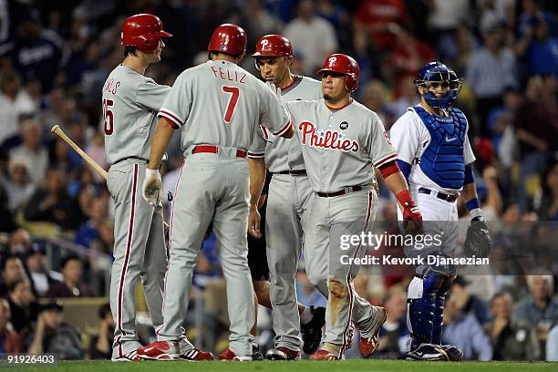 Carlos Ruiz of the Philadelphia Phillies gets congratulated by teammates Pedro Feliz, Cole Hamels and Raul Ibanez after, Ruiz, hit a three run home...