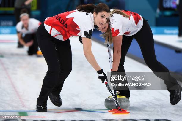 Canada's Lisa Weagle brushes in front of the stone during the curling women's round robin session between the the US and Canada during the...