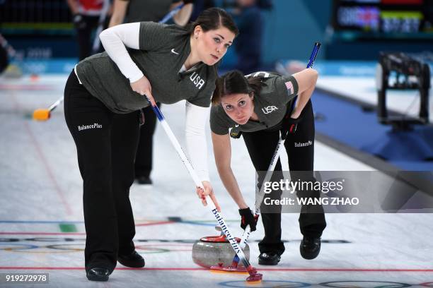 S Tabitha Peterson and Becca Hamilton brush in front of the stone during the curling women's round robin session between the the US and Canada during...