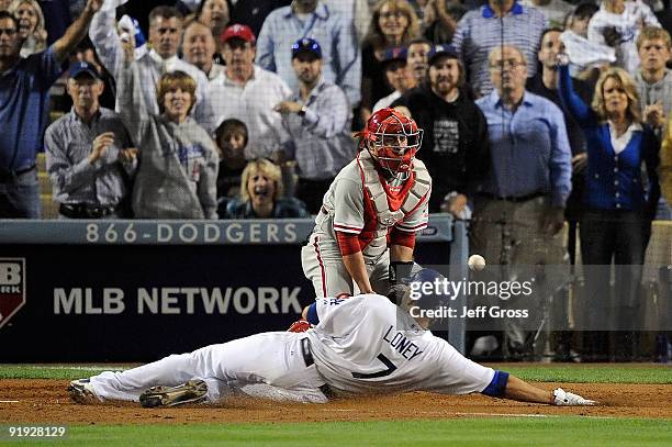 James Loney of the Los Angeles Dodgers slides in safely against catcher Carlos Ruiz of the Philadelphia Phillies to score a run on a single hit by...