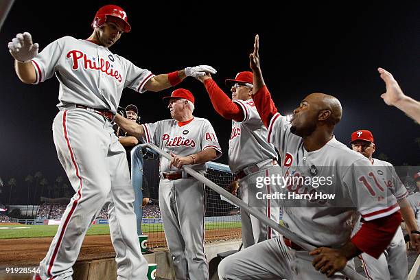 Raul Ibanez of the Philadelphia Phillies get congratulated by his teammates including, Jimmy Rollins, as he enters the dugout after hitting a three...