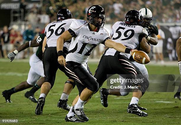 Quarterback Zach Collaros of the Cincinnati Bearcats hands the ball off against the South Florida Bulls during the game at Raymond James Stadium on...