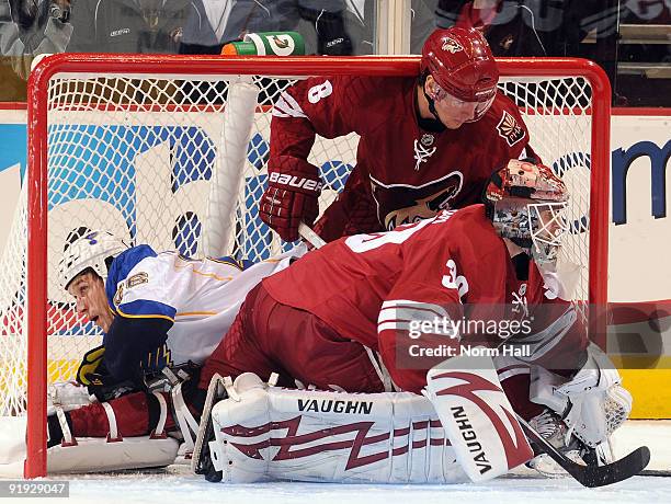 Crombeen of the St. Louis Blues winds up in the net as Ilya Bryzgalov and Scottie Upshall of the Phoenix Coyotes watch the puck on October 15, 2009...