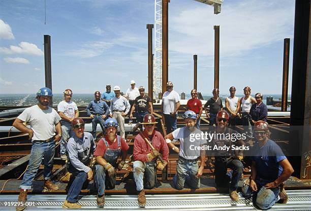 men in hard hats on high rise construction posing for photo - arbeiter baustelle stock-fotos und bilder