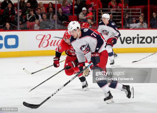Josh Anderson of the Columbus Blue Jackets skates with the puck as Elias Lindholm of the Carolina Hurricanes pursues during an NHL game on December...