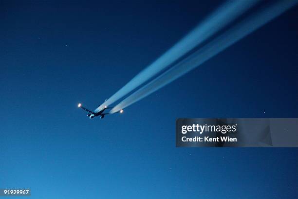 aircraft with blurred contrails - vapour trail stock pictures, royalty-free photos & images
