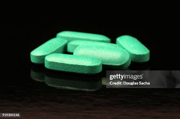 green pills on a black background - mdma stock pictures, royalty-free photos & images