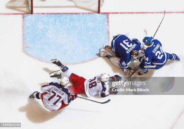 Frederik Andersen of the Toronto Maple Leafs covers the puck with teammate Kasperi Kapanen against Boone Jenner and Josh Anderson of the Columbus...