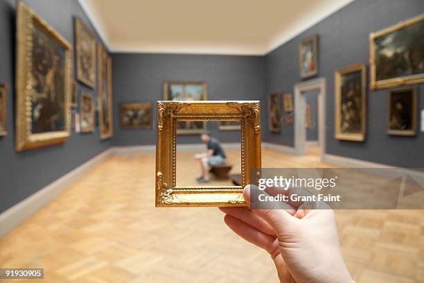 blurry young man framed by small golden frame - gallery imagens e fotografias de stock