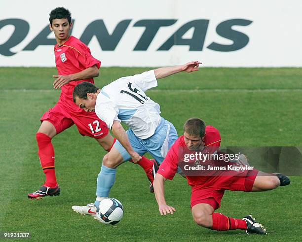 Adam Casey of Sydney is tackled by Andrew Ciarla and Perry Mitris of United during the round six National Youth League match between Adelaide United...